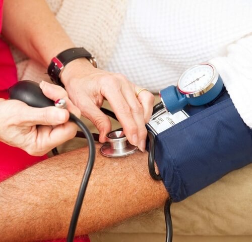 provider of home health care in Okotoks taking elderly patient's blood pressure