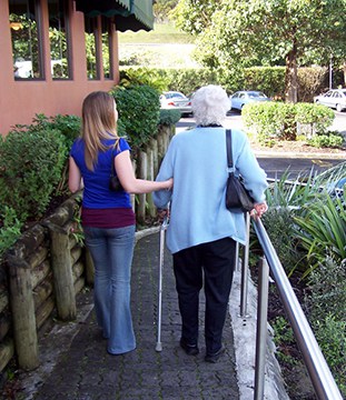 caregiver in Calgary walking beside elderly patient