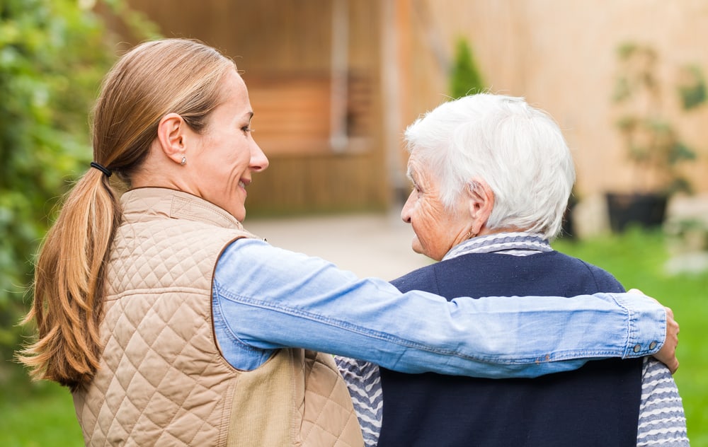 provider of dementia care in Calgary sitting and hugging elderly patient