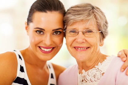 provider of Alzheimer's care in Edmonton standing and smiling with senior patient