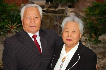 Elderly Couple Posing in Front of a Waterfall