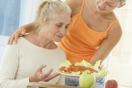 Woman Giving Food to Elderly Woman